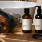 Shampoing cheveux colorés sans sulfate, flacons sans logo près d’une mèche colorée